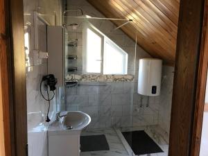 a bathroom with a sink and a window at PBJ Apartman in Pilisborosjenő
