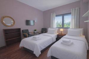 a bedroom with two beds with white sheets and a window at SUNNY 3, Two-bedroom apartment with parking in Komotini