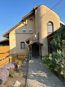 a house with a brick walkway in front of it at PBJ Apartman in Pilisborosjenő