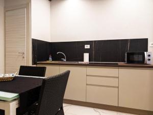 a kitchen with a table with chairs and a microwave at Le torri Virgo in Fossano