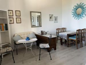 a living room with a table and chairs and a mirror at Andrea E Valentina in S'archittu Cuglieri