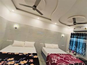 a bedroom with two beds and a ceiling at Amirtham Holiday Home in Kovakulam