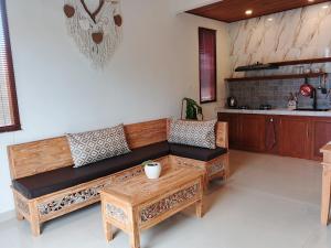 a living room with a wooden couch and a table at Umakami Pertiwi Villas in Ubud