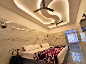 a bedroom with a ceiling fan and a bed at Amirtham Holiday Home in Kovakulam