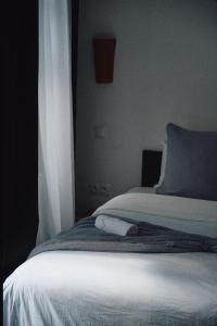 a bed with a white blanket and a window at Nbta House in Tangier