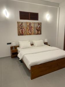 a bedroom with two beds and paintings on the wall at Ceylon tea resort Ella in Ella