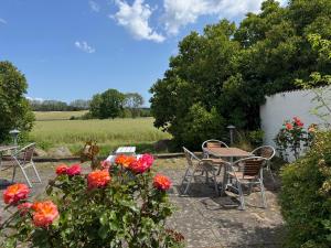 a patio with a table and chairs and flowers at Ravlunda Bränneri in Kivik +16 photos
