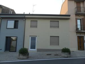 a white house with two potted plants in front of it at Carme31 Sirmione in Sirmione