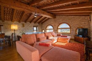 a living room with a large couch and a tv at Catalunya Casas Captivating Villa in the Vineyard close to Sitges in Bisbal del Penedès