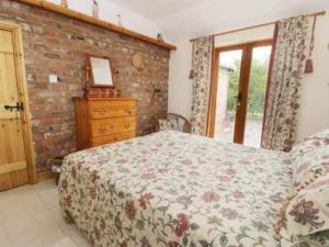 a bedroom with a bed and a brick wall at Wolds View in Cornisholme