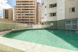 a swimming pool in front of two tall buildings at Aqui você se hospeda e garante total privacidade, além de conforto, praticidade e segurança in Curitiba