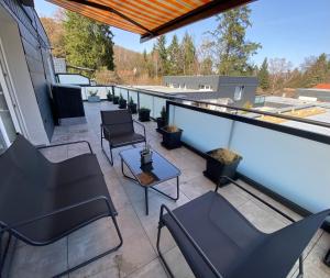 a patio with chairs and tables on a balcony at The Lodge Bad Harzburg in Bad Harzburg