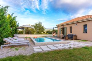 a backyard with a swimming pool and a house at Villa Kalligoni in Kalligónion