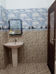 a bathroom with a sink and a mural of a beach at Jb Villa in Bona Vista