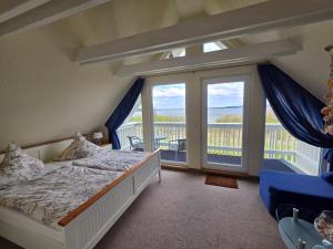 a bedroom with a bed and a balcony at Ferienhaus Seestern direkt am Plauer See in Plau am See