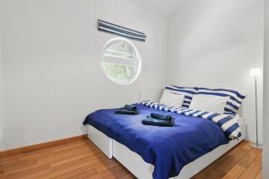 a bedroom with a bed with blue sheets and a window at Sunset view Housboat with sundeck,AC&Heating in Bratislava