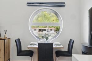 an oval window in a dining room with a table and chairs at Sunset view Housboat with sundeck,AC&Heating in Bratislava