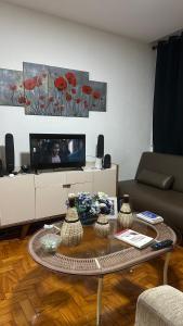 a living room with a coffee table and a tv at Quarto privativo confortável próximo a ufba, praia, comercio e zoológico in Salvador