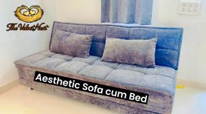 a blue couch in a room with a sign that reads aesthetic solla gun bed at The Velvet Nest - Gurgaon - Luxurious Single Bedroom Private Villa with Garden in Gurgaon