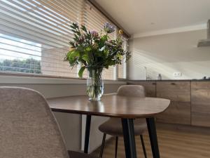 a vase of flowers sitting on top of a table at Wellness huisje Sonne Oase in Lanaken