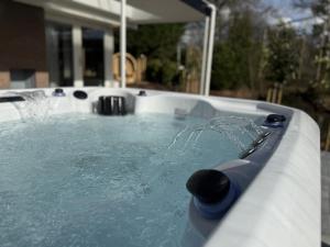 a jacuzzi tub with water pouring into it at Wellness huisje Sonne Oase in Lanaken