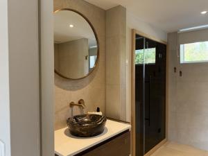 a bathroom with a sink and a mirror at Wellness huisje Sonne Oase in Lanaken