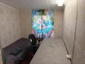 a room with a table and a bed and a painting on the wall at Ofiss 24 in Riga