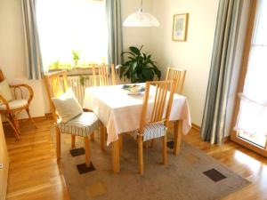 a dining room table and chairs with a white table and a table and chairsktop at Ferienwohnung Edmeier in Bernau am Chiemsee