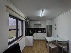 a kitchen with white cabinets and a table with chairs at Quinta dos Carvalhais - Serra da Estrela in Fornos de Algodres