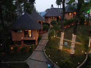 a house with lights in front of a yard at Kashmeeram Vythiri Wayanad Premium Pool Resort in Vayittiri