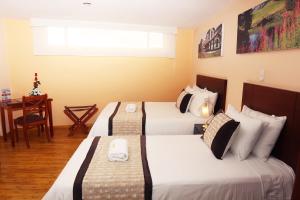a hotel room with two beds and a table at Hotel Xilon Resort Pasto in Pasto +2 photos
