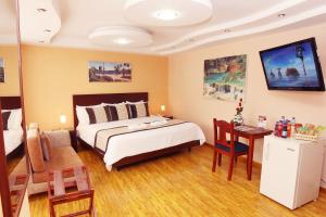 a bedroom with a bed and a table and a desk at Hotel Xilon Resort Pasto in Pasto