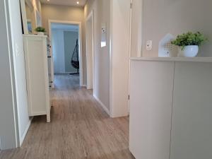a hallway of an apartment with white cabinets and wood floors at Ferienwohnung Wandelweg in Kamp-Lintfort