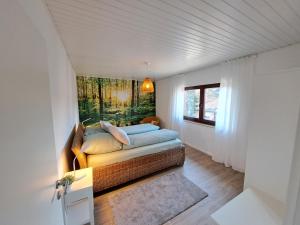 a bedroom with a bed with a painting on the wall at Ferienwohnung Wandelweg in Kamp-Lintfort