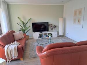 a living room with two couches and a television at Ferienwohnung Wandelweg in Kamp-Lintfort +30 photos