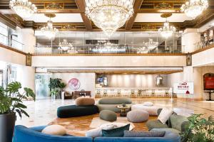 a lobby with couches and tables and chandeliers at T Hotel in Taichung