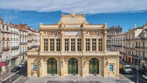 a large building with a clock on top of it at Lou Occitan- Appartement cosy centre Béziers in Béziers