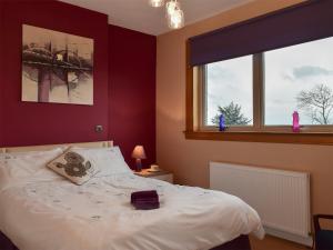 a bedroom with a white bed and two windows at Bankhead Farm Cottage in Donibristle +10 photos