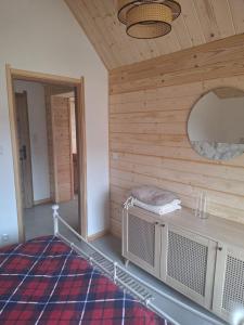 a room with a wooden wall and a mirror at CHATKA u TADKA in Nowy Sącz