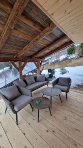 a pavilion with couches and tables on a wooden floor at CHATKA u TADKA in Nowy Sącz