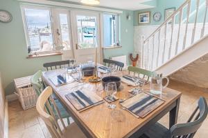 a dining room with a wooden table and chairs at Waterfront Boathouse - Drift Cottage in Plymouth