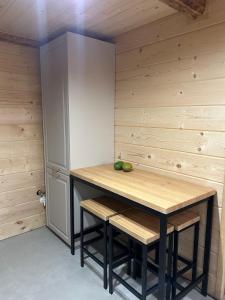 a kitchen with a table and two stools at CHATKA u TADKA in Nowy Sącz