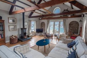 a living room with a couch and a table at Waterfront Boathouse - Drift Cottage in Plymouth