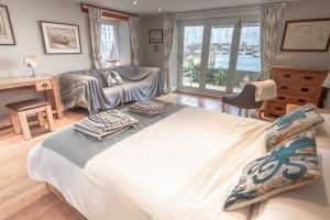 a bedroom with a large bed and a living room at Waterfront Boathouse - Drift Cottage in Plymouth