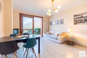 a living room with a table and chairs and a couch at LA VISTA by Design Studio in Bellano