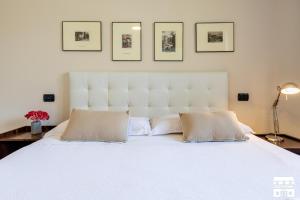 a bedroom with a large white bed with two pillows at LA VISTA by Design Studio in Bellano +22 photos