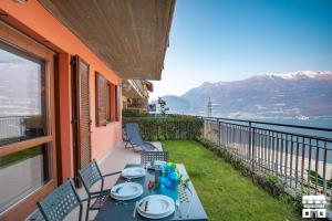 a table on a balcony with a view of the water at LA VISTA by Design Studio in Bellano