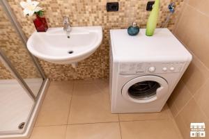 a bathroom with a washing machine and a sink at LA VISTA by Design Studio in Bellano