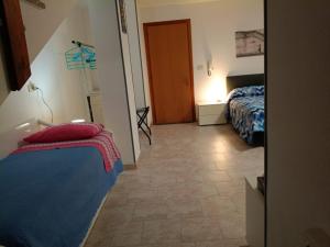 a bedroom with a blue bed and a door at Da Rita in Villanova Monteleone