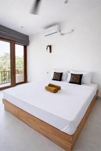 a bedroom with a large bed with white sheets at Surf Villa Hiriketiya in Hiriketiya